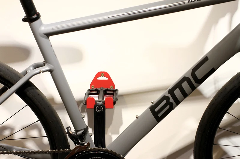 Wall-mounted bike rack with pedal attachment