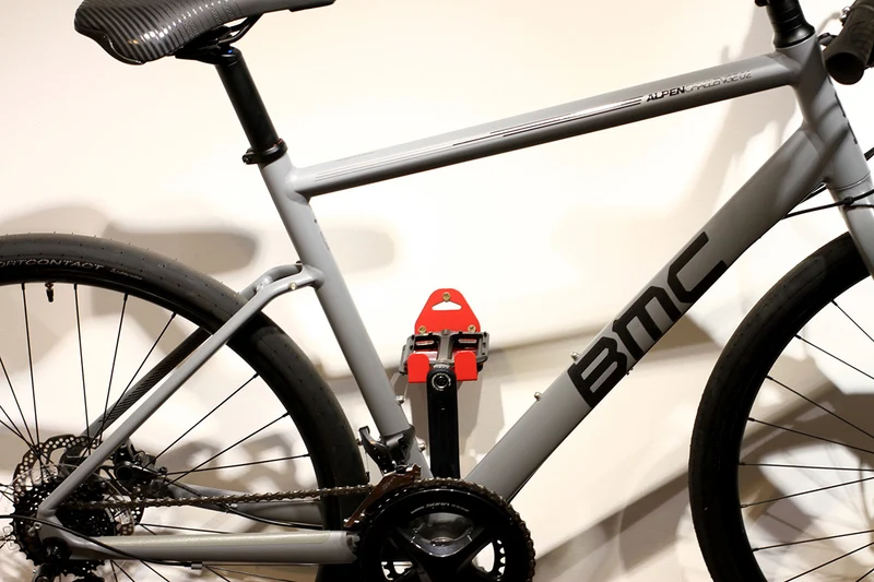Wall-mounted bike rack with pedal attachment