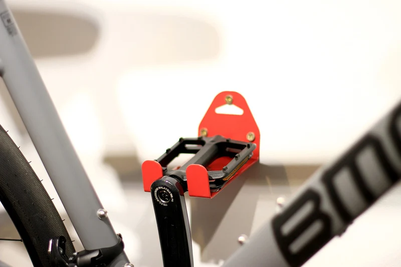 Wall-mounted bike rack with pedal attachment
