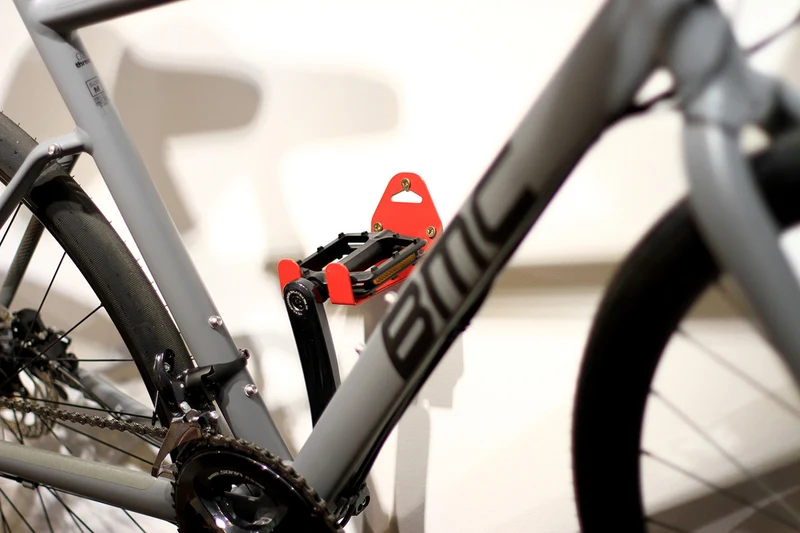 Wall-mounted bike rack with pedal attachment