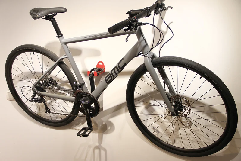 Wall-mounted bike rack with pedal attachment